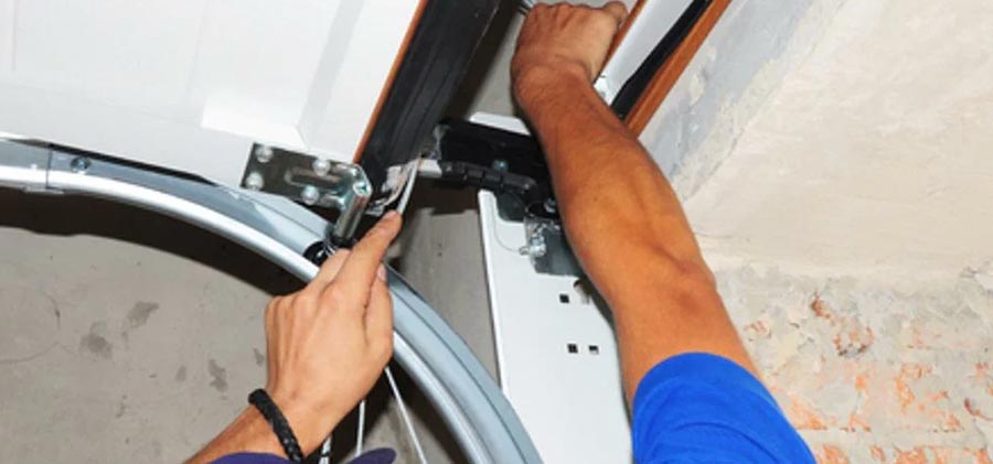 Technician inspecting a broken garage door extension spring